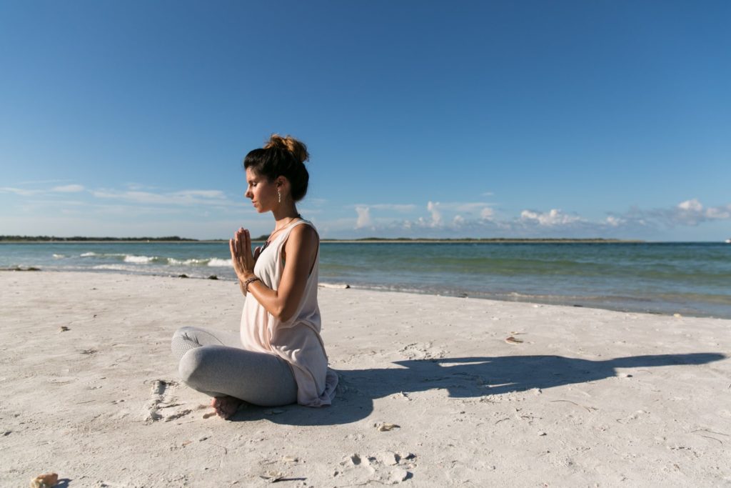 海辺でお祈りをする女性